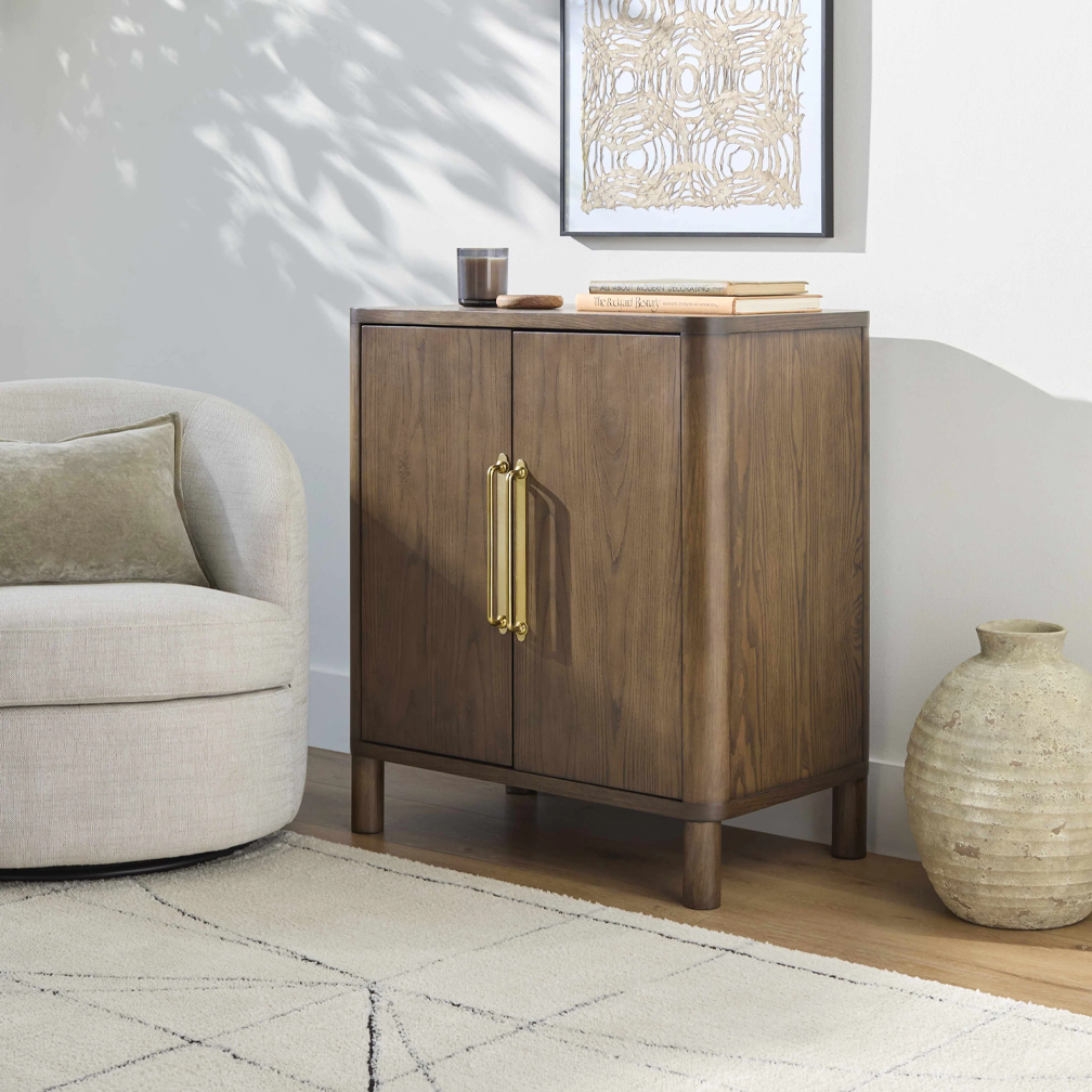 Modern dark walnut storage cabinet featuring two doors and gold hardware, ideal for living room or entryway.