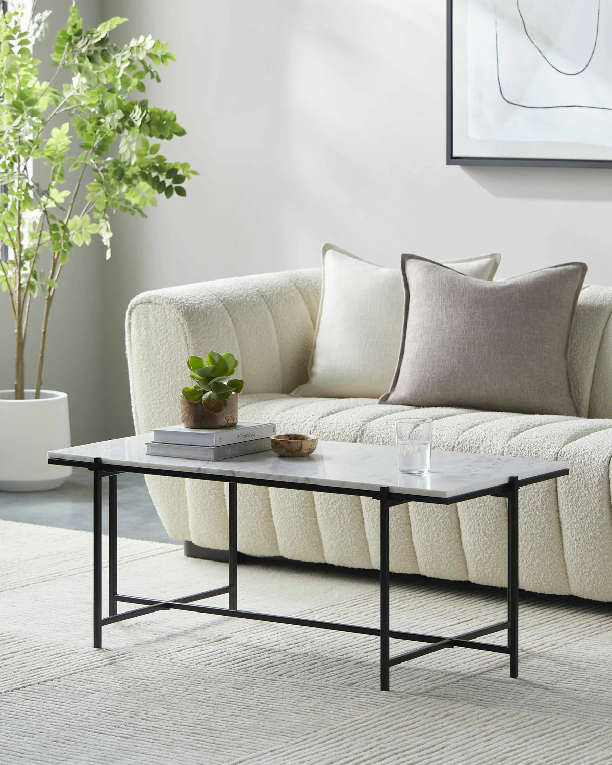 Modern living room with a beige sofa, coffee table, and decorative items.